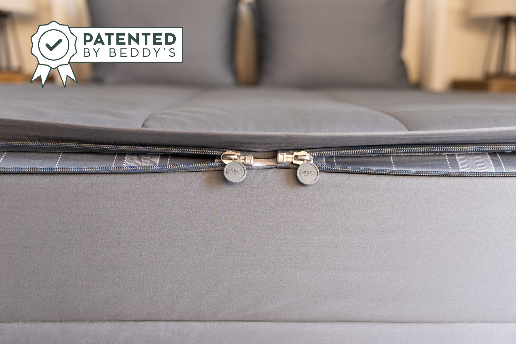 a close up shot of the dual zipper feature on a set of gray zipper bedding, showcasing that there are two L-shaped zippers, one on each side of the bed