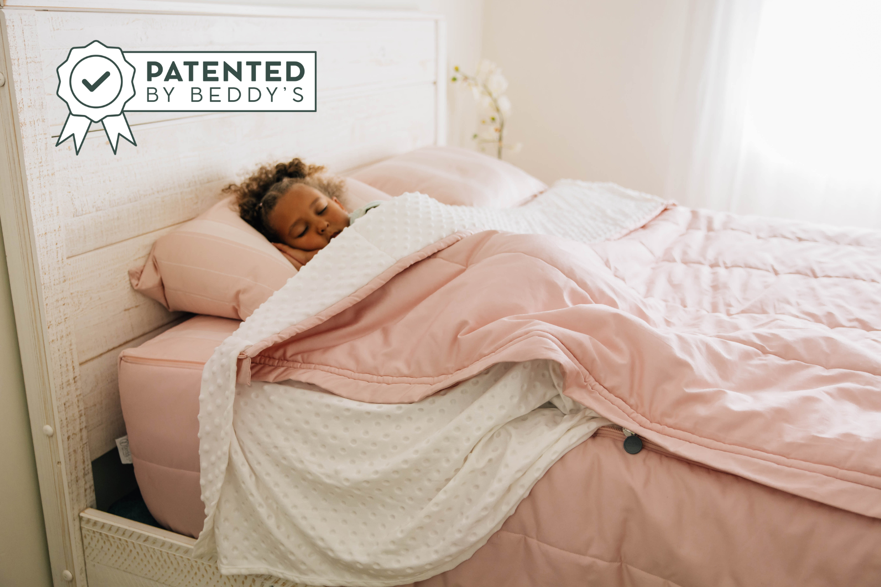 a young girl asleep in a bed made with pink zipper bedding