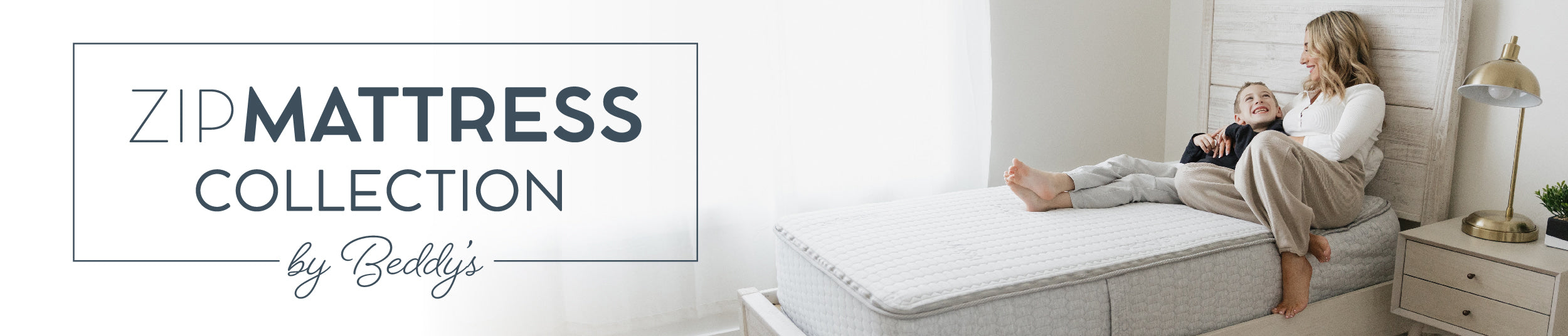 A collection page header for the ZipMattress collection by Beddy;s, featuring a photo of a mother and son sitting together on a twin mattress, smiling at each other.