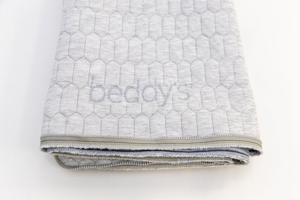 A close up view of a replacement mattress top folded on a white background.