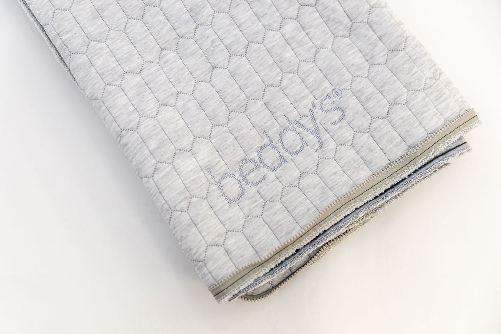 A close up view of the logo on the replacement mattress top folded on a white background.