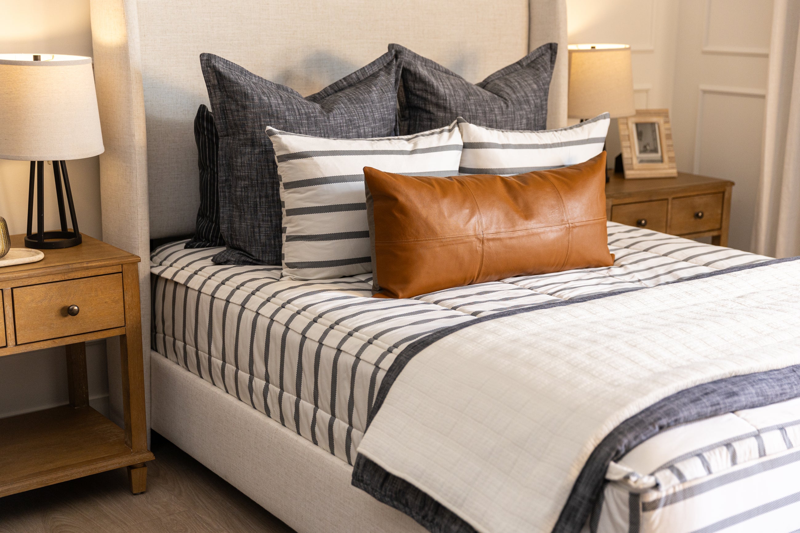 White and black zipper bedding with white blanket and charcoal and tan accessories