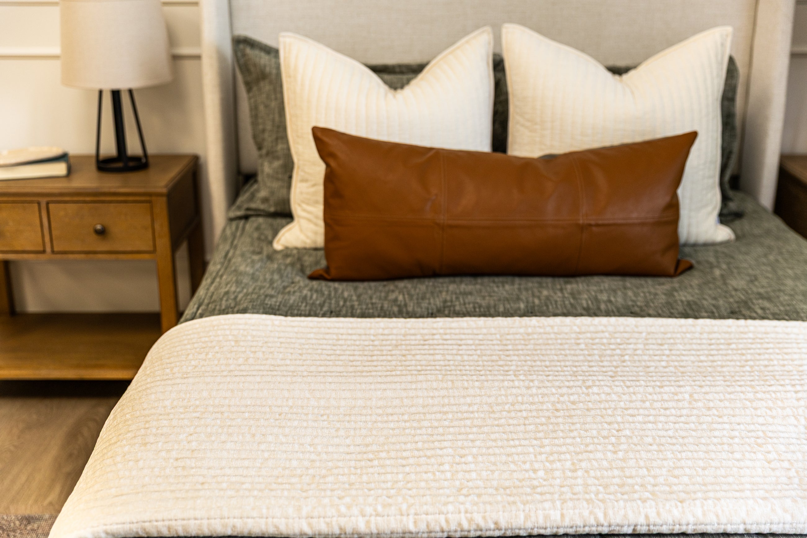 Cream blanket on green zipper bedding with cream and tan accessories