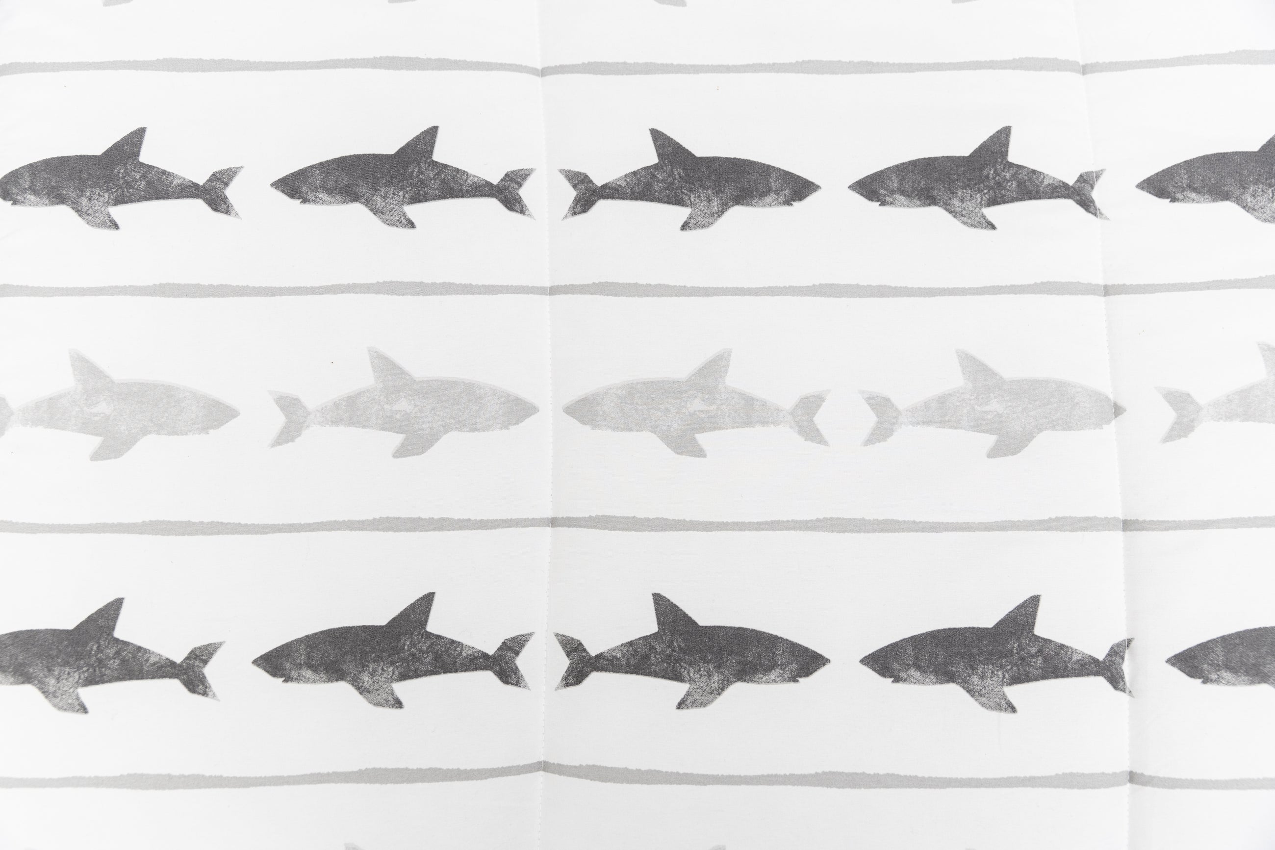 A close up of the shark print on a set of shark kids zipper bedding