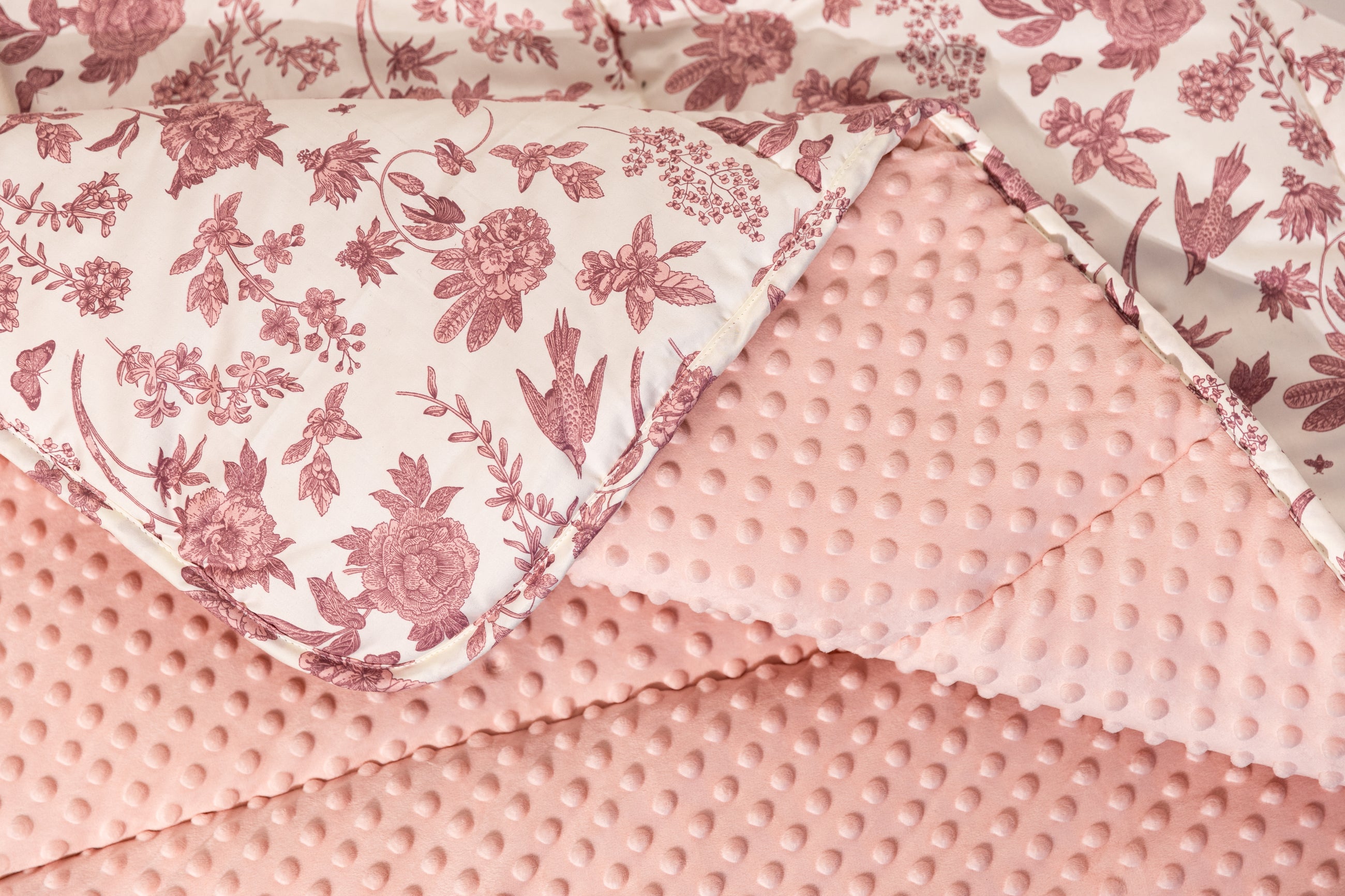 Photo that shows both pink minky and white and pink floral blanket