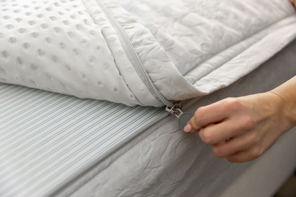 Close up photo of zipper being pulled on blue floral zipper bedding