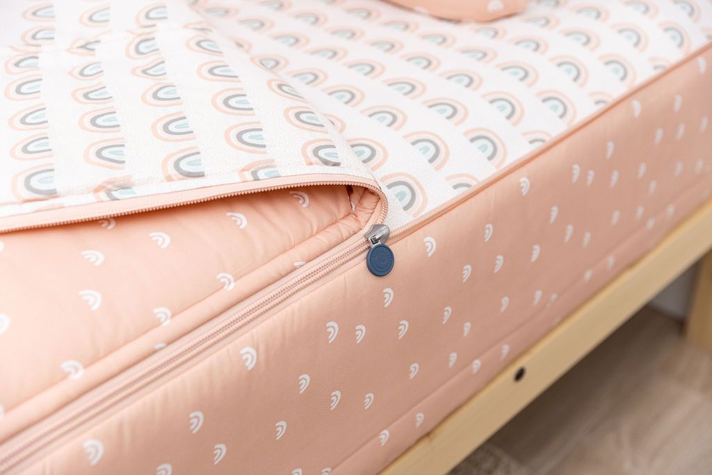 peachy pink rainbow printed zipper bedding unzipped showing pastel rainbow sheet interior