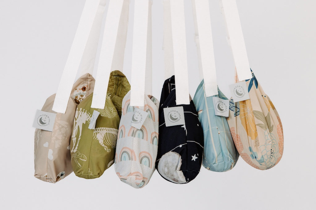 6 bags holding children's blankets inside hanging in a row
