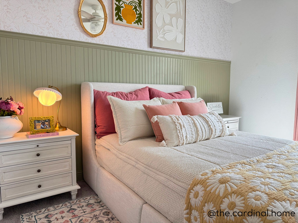 A queen bed made with cream waffle textured zipper bedding and an assortment of pattern pillows and blankets.