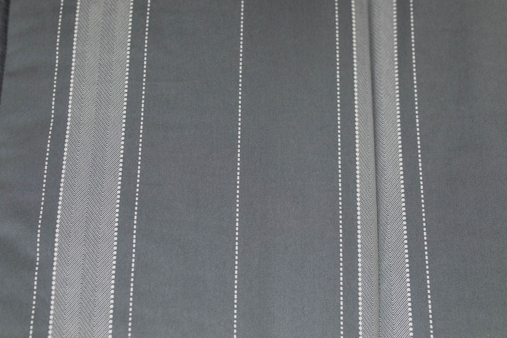 A close up detailed view of the gray striped interior of a gray zipper bedding.