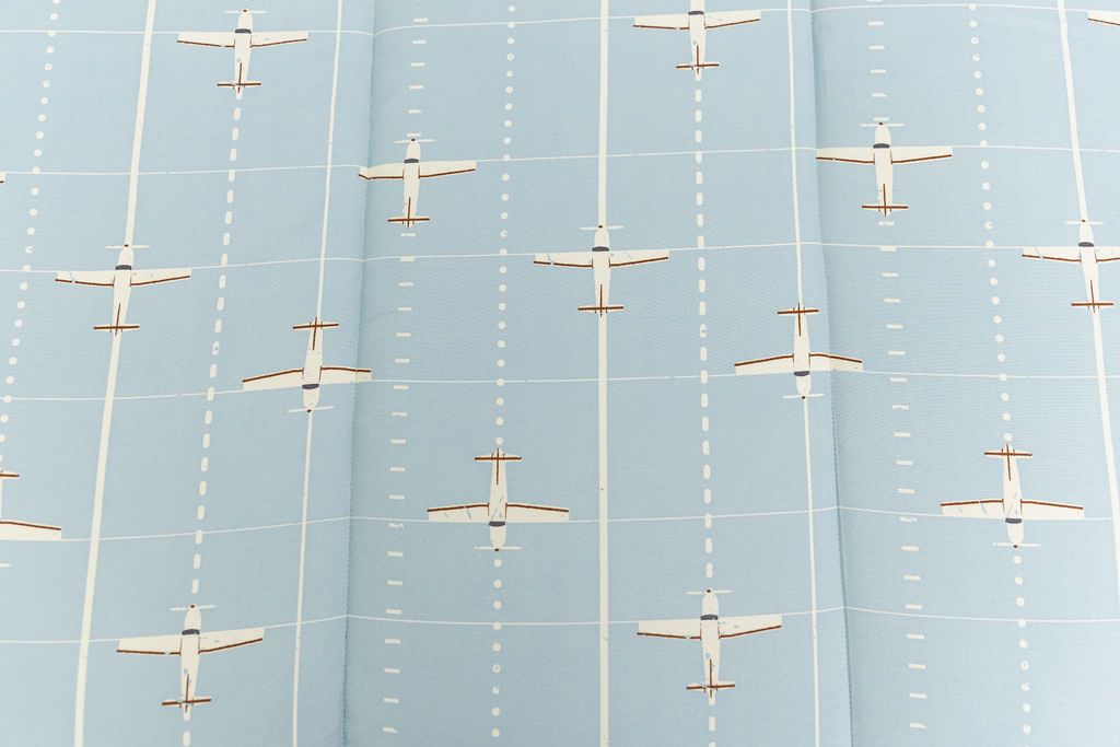up close of light blue bedding with airplane design