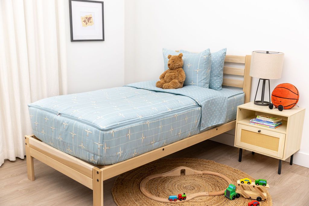 bedroom with twin bed decorated with light blue zipper bedding and airplane design with toys on the ground