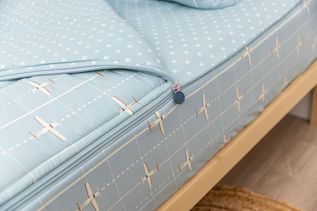 light blue zipper bedding with airplane design unzipped showing coordinating sheet interior