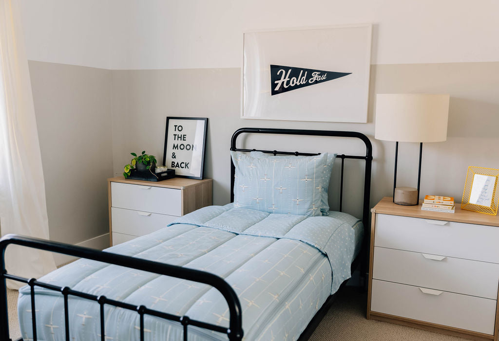 bedroom with twin bed decorated with light blue zipper bedding and airplane design