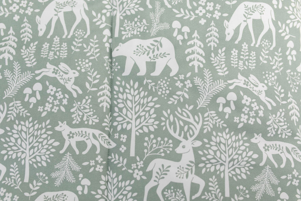 A close up on the print of a sage green forest animal kids zipper bedding set