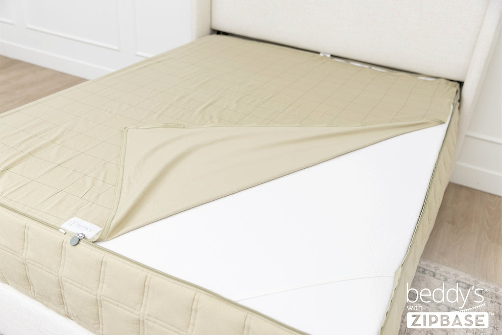 A ZipBase sheet partially unzipped and pulled back to show how it detaches from the rest of the base sheet wrapped around the sides of the mattress.