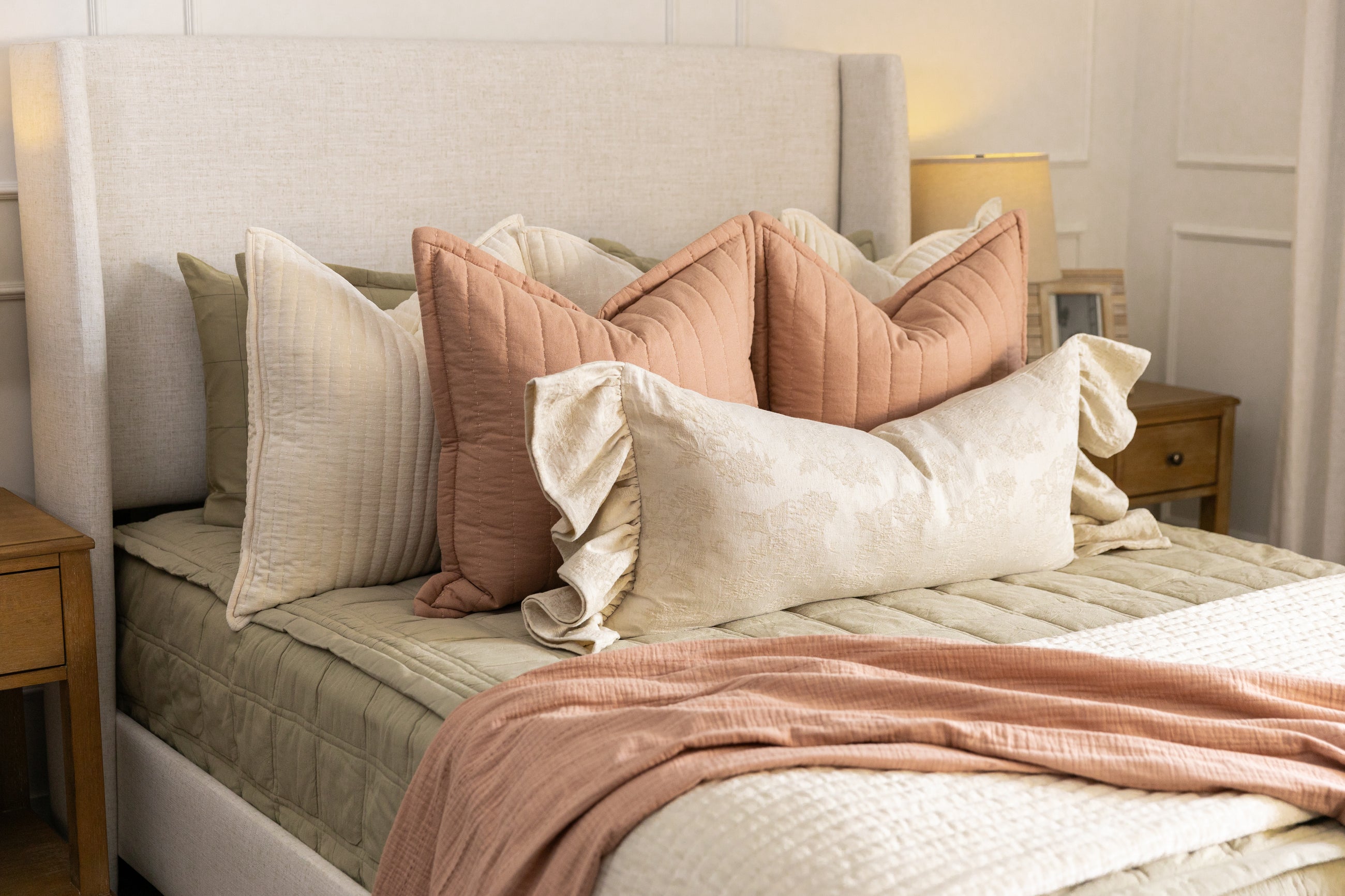 Green bedding with cream and terracotta accessories