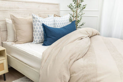 Tan duvet bedding styled with matching blue, tan and white pillows