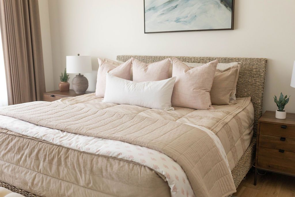Tan zipper bedding styled with tan, white and pink pillows and blankets