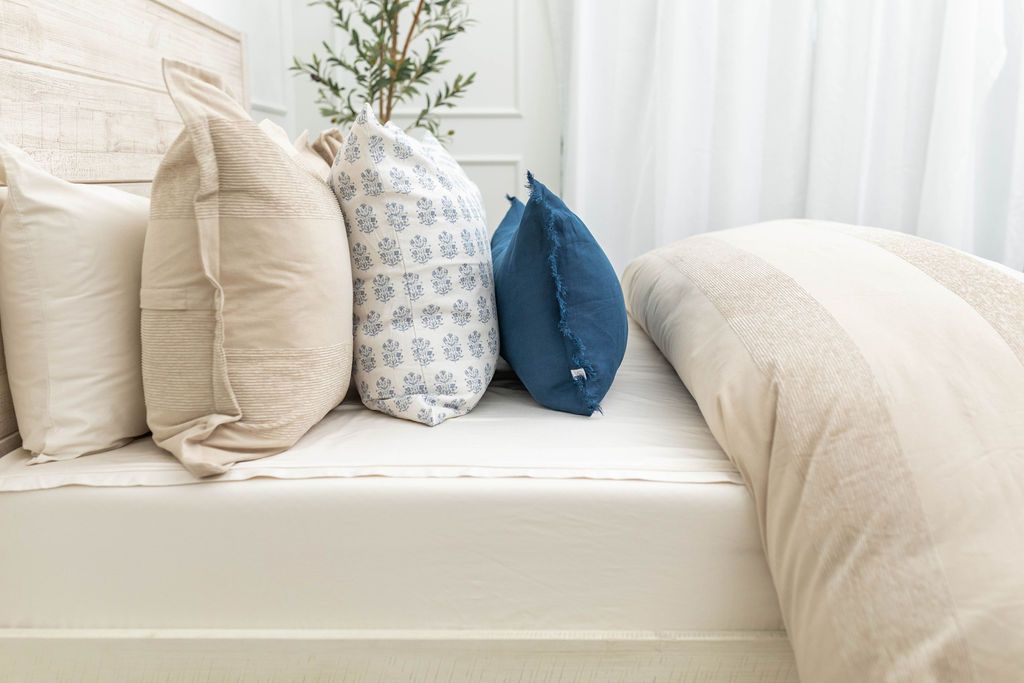 Tan duvet bedding on bed with matching accessories