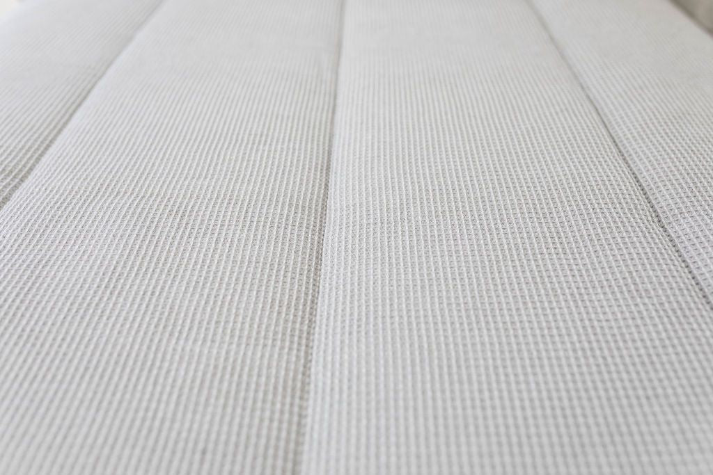 A close up of the waffle textured detail on light gray zipper bedding.