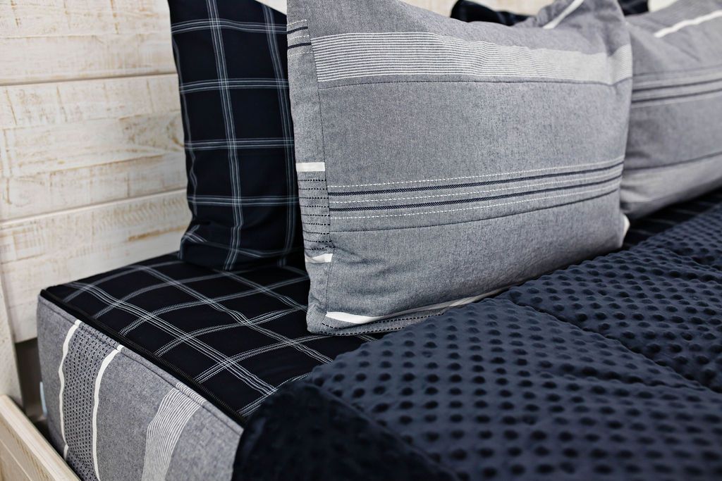 Deep navy woven stripe bedding folded down showing navy grid pattern sheet with navy minky