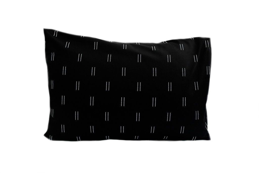 A black pillowcase with a two white line repeated pattern.