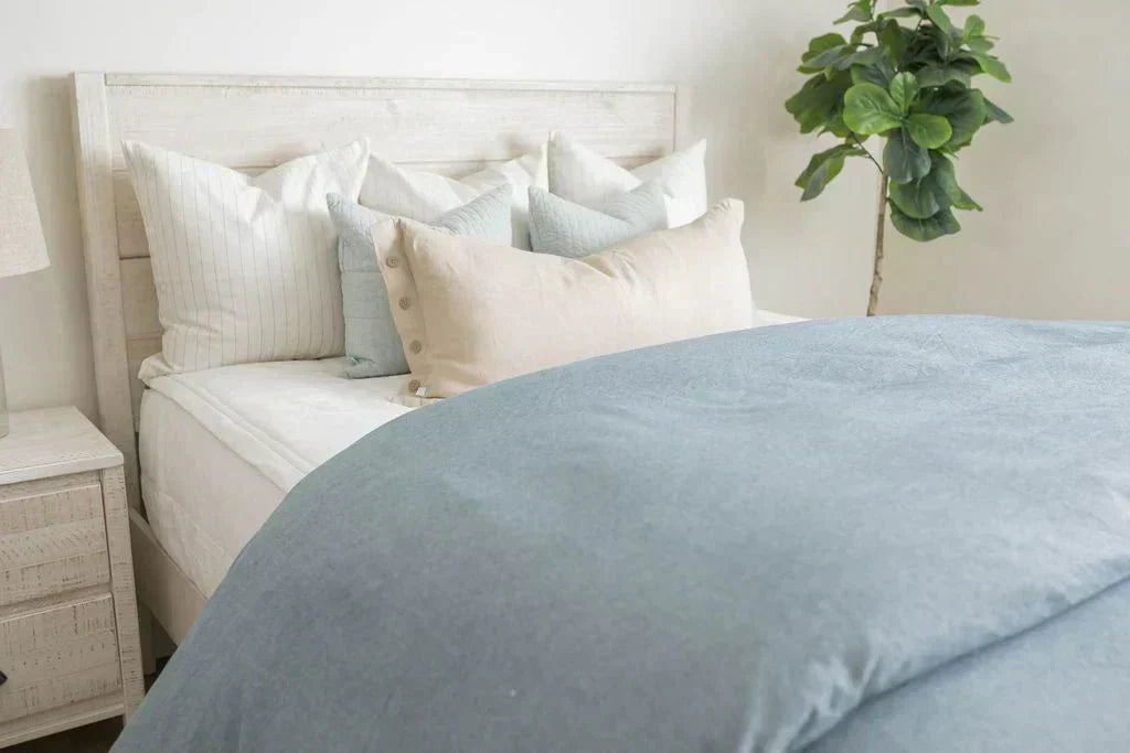 
      A twin bed made with white zipper sheets and a chambray blue duvet cover.
    