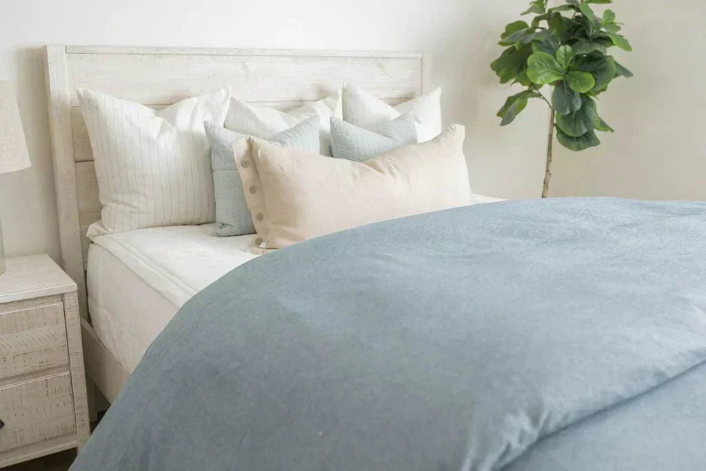 
      A twin bed made with white zipper sheets and a chambray blue duvet cover.
    