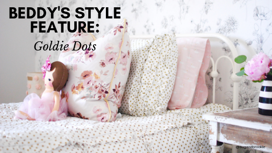 
      A twin bed made with gold dotted zipper bedding and pink floral accessories
    