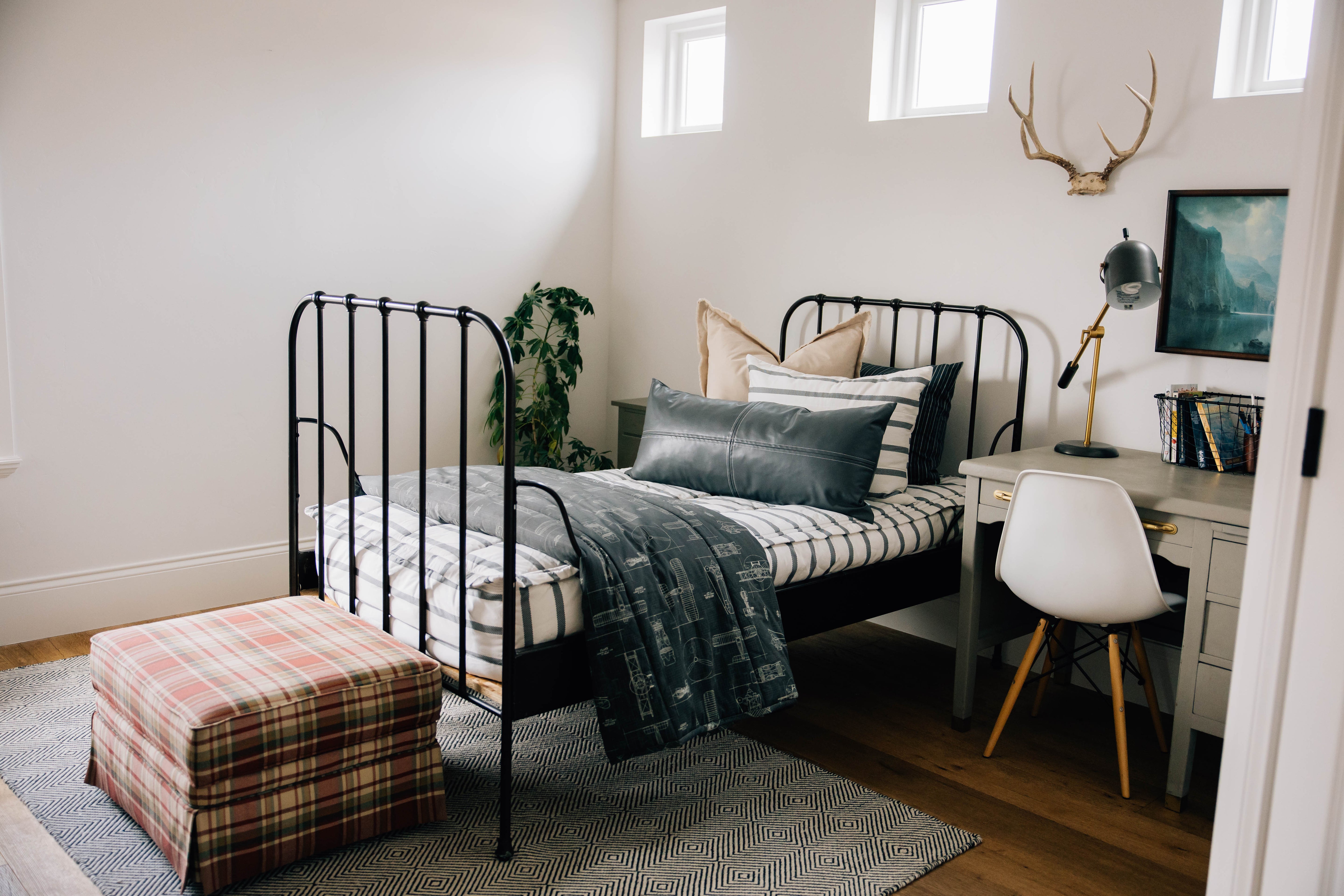 
      A boy's room with a twin bed made with striped zipper bedding and a desk next to the bed, an overall modern look in the room.
    