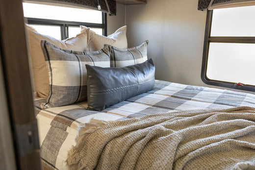 
      An RV bed made with plaid zipper bedding.
    