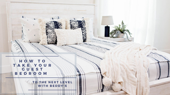 
      A queen bed in a guest room made with striped zipper bedding and neutral bedding accessories
    