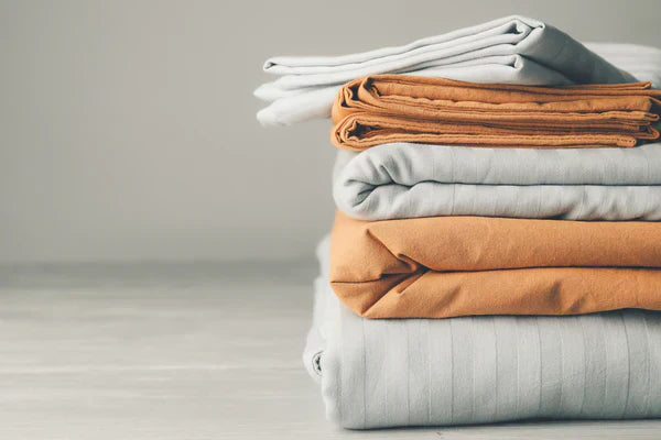
      Gray and orange sheets stacked on top of each other on a gray background.
    