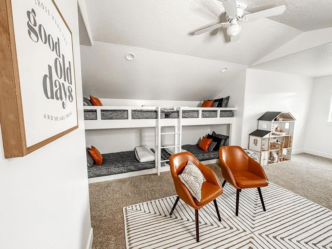 
      a bunk room featuring four built in bunk beds made with dark gray zipper bedding.
    