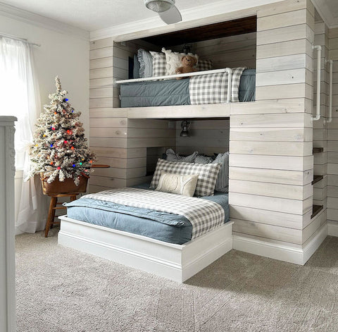 
      A farmhouse built in bunk bed with light blue zipper bedding and holiday decor.
    