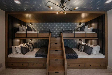 
      A room with dark wood style built in bunk beds featuring a variety of sized beds with Beddy's bedding.
    