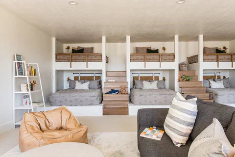 
      A bunk bed room with three full beds on the main level and three full beds on the top level, all featuring gray zipper bedding.
    