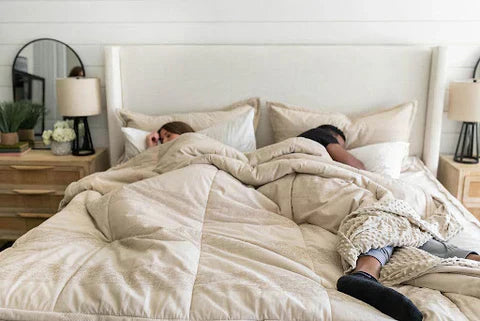 
      A man and woman asleep in a bed with tan Beddy's bedding and a neutral bed frame.
    