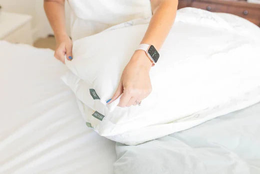 
      Someone arranging the inserts of an adjustable pillow.
    