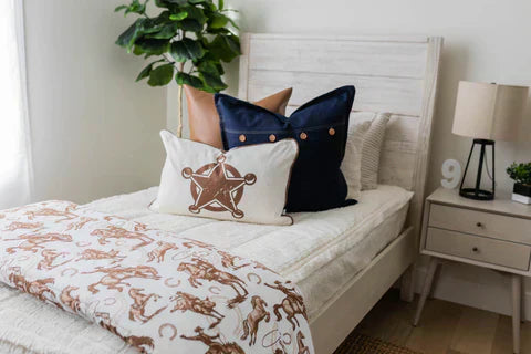 
      A twin size bed made with zipper bedding, featuring cowboy themed throw blankets and pillows.
    