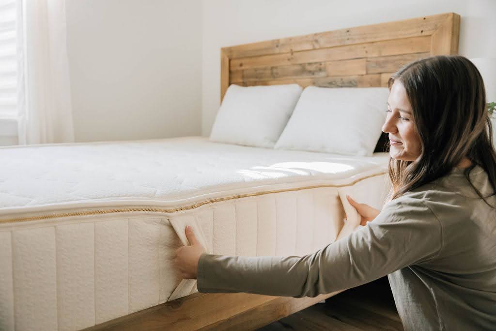 
      woman holding side handles white zip mattress
    