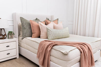 A bed made with Beddy's cream zipper bedding and an assortment of bedding accessories.