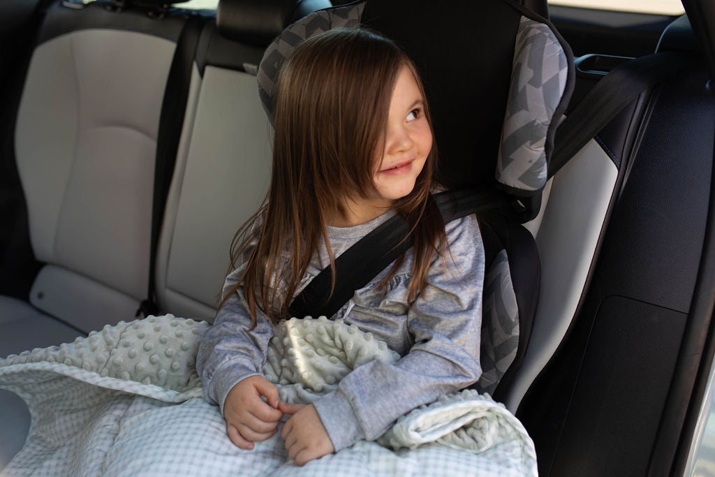 Child in car seat with white and green checkered mini blanket