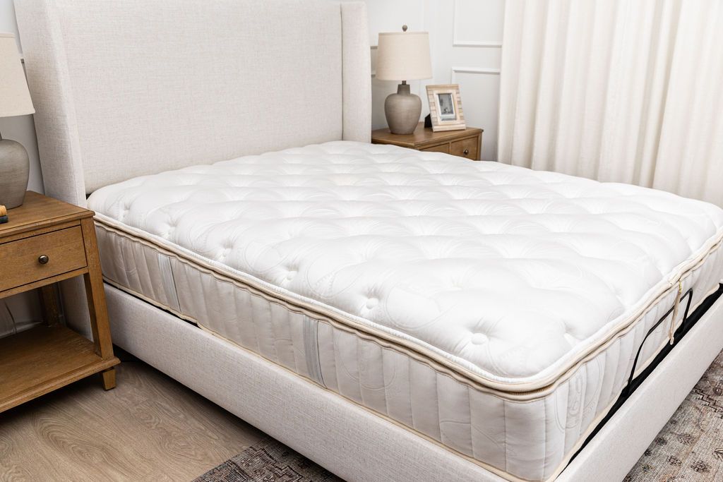 A side view of a tufted zipper mattress sitting in a bed frame