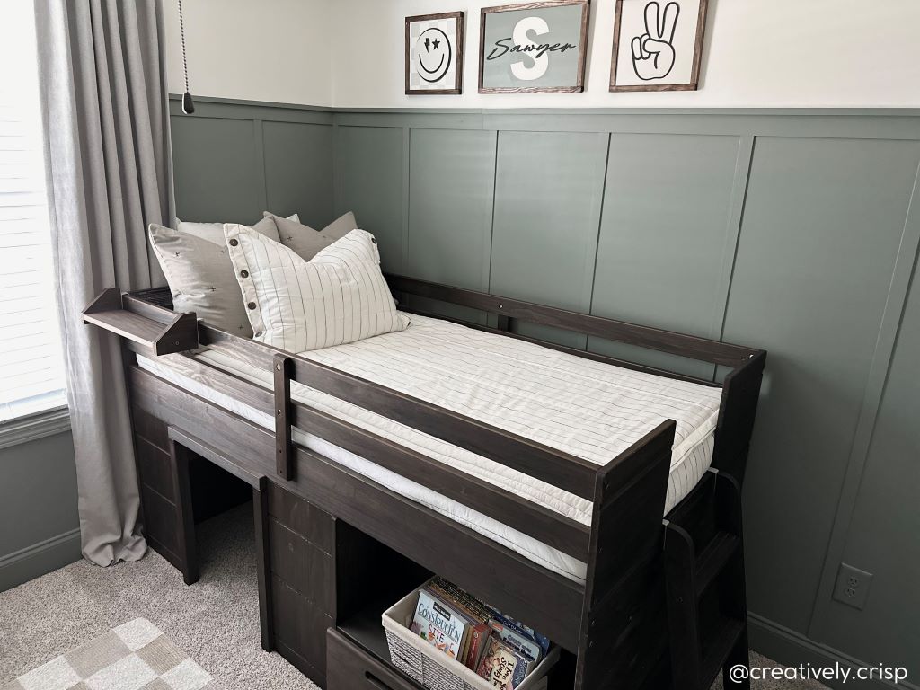 A twin bed loft bed made with white and pinstripes zipper bedding and neutral pillows.