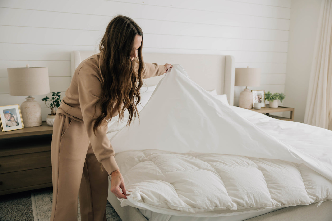 A woman opening her duvet to look at the duvet insert.