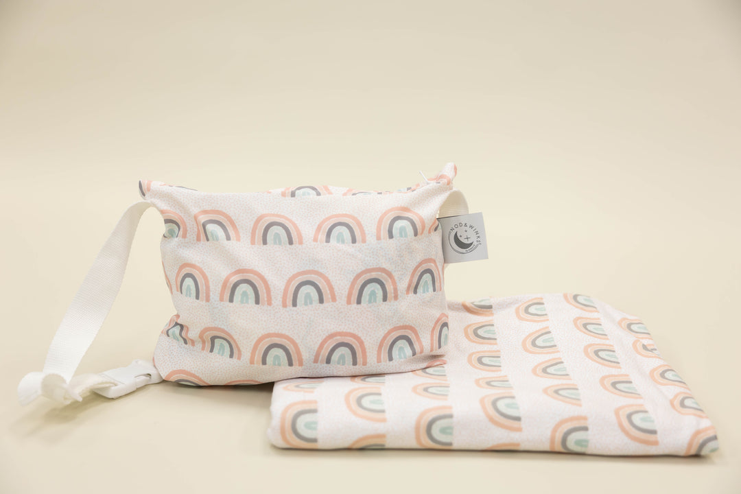Kid travel blanket with rainbows and a coordinating pouch with a white strap.