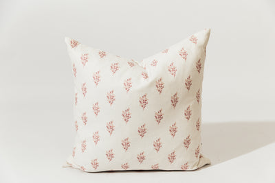 A pink floral pillow on a white backdrop.