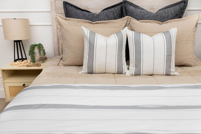 Gray and white striped pillow and blanket on tan zipper bedding